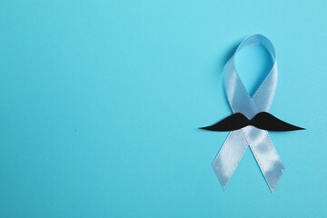 Wall Mural - Light blue ribbon and fake mustache on color background, top view with space for text. Prostate cancer awareness