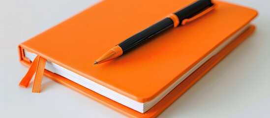Poster - An orange notebook diary and pen displayed on a white background with copy space image