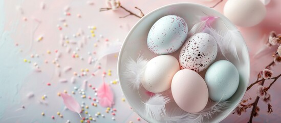 Aufkleber - Top view of a white bowl holding Easter eggs and feathers against a bright background with copy space for an image