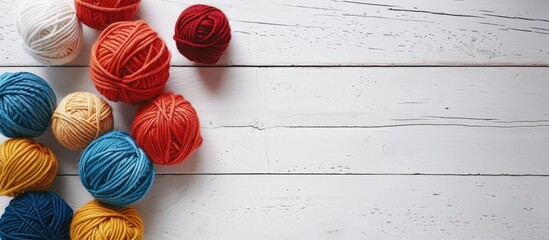 Poster - Woolen yarn balls arranged neatly on a clean white wooden tabletop providing ample copy space image