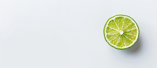 Poster - Top view of a lime slice on a white background with ample copy space image for text creating a flat lay pattern