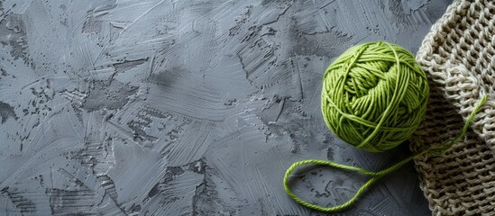 Aufkleber - Grey backdrop with crocheted pattern and green yarn ball offering copy space image