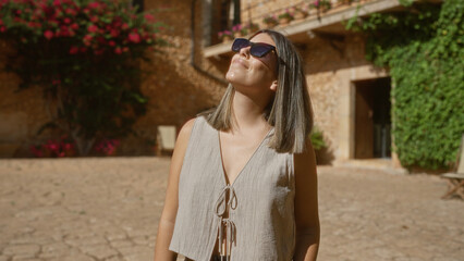 Poster - Young woman enjoying sunny day outdoors in beautiful mallorca, spain, surrounded by mediterranean architecture and vibrant flowers