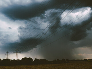 Poster - Regen und Gewitterwolken über Strommasten