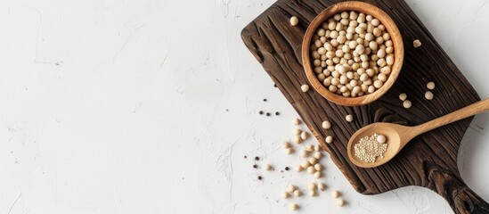 Poster - A wooden board with a brown bowl filled with white pepper peas accompanied by a spoon set against a white background creating space for additional images