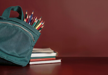 Aufkleber - Green backpack of colored pencils with books on a desk with copy space, back to school concept