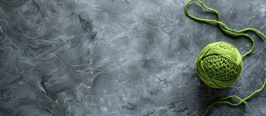 Aufkleber - Grey backdrop with crocheted pattern and green yarn ball offering copy space image