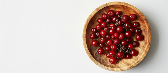 Aufkleber - Top down view of ripe viburnum berries in a wooden bowl on a white background with suitable copy space image