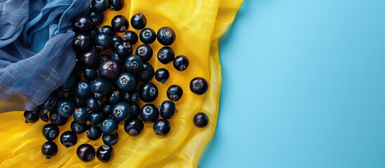 Wall Mural - Top view macro image of bilberries on yellow and light blue kitchen textiles with copy space image