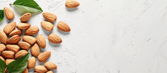 An overhead shot of almond nuts stacked on a white surface with room for text or graphics such as a copy space image