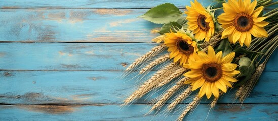 Poster - Background featuring a bouquet of yellow sunflowers and wheat ears on blue painted wooden boards Copyspace for text