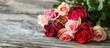 © vxnaghiyev - A beautiful bouquet of roses on a wooden background suitable for a Valentine card Colorful flowers paired with a Valentine s Day heart toy Set against a wooden backdrop with copy space A bunch of var