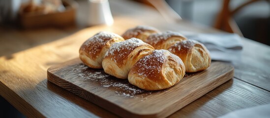 Poster - Breads on a wooden board dusted with icing sugar on a wooden table for breakfast. with copy space image. Place for adding text or design