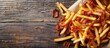 © Ilgun - Flat lay of tasty French fries with bacon on a wooden surface offering room for text in a copy space image