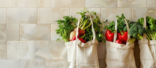 Poster - Close up view of eco bags displaying an assortment of fresh vegetables against a light tile backdrop with copy space image