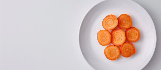 Sticker - Top down view of sliced fresh carrot on a white plate against a white background with copy space image Displays a fresh vegetable for a salad a healthy flat lay composition