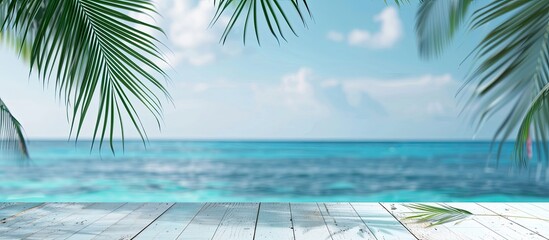 Poster - Blurry blue ocean with palm leaf in the background positioned on a white wooden table with copy space image