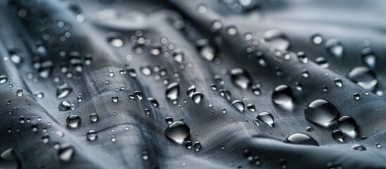 Water droplets on a grey fabric with hydrophobic properties serving as a textile backdrop with ample copy space image