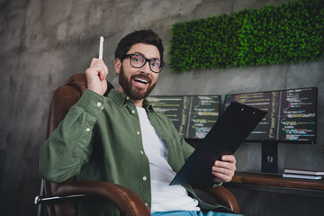 Canvas Print - Portrait of professional hacker young man point pen clipboard computer desk loft interior office indoors