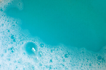 Foam in blue water. Blue foam. Water with foam bubbles. Blue background