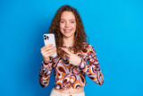 Fototapeta Panele - Photo portrait of pretty young girl hold point device wear trendy colorful outfit isolated on blue color background