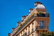 © ON-Photography - Flat iron-shaped residential building in Paris (France) with wrought-iron balustrades, sandstone façade and tin roof on a sunny day. Typical building on the large boulevards of the french metropolis.
