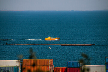 Wall Mural - A small yellow yacht rushes in the blue sea