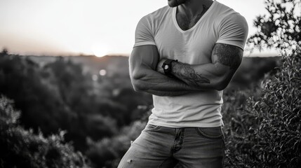 Sticker -  A monochrome image of a man in a white T-shirt, arms folded across his chest, facing the camera