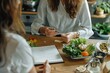 © Iftikhar alam - A woman sitting at a table with a plate of food in front of her while discussing meal plans with a nutritionist, Nutritionist discussing meal plans with a client
