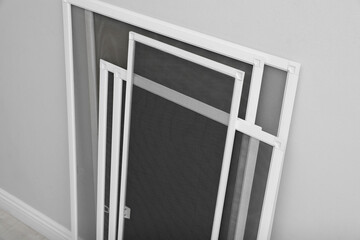 Wall Mural - Set of window screens near light grey wall indoors, above view