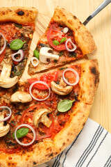 Wall Mural - Tasty pizza with basil, mushrooms, onion and tomato on wooden table, top view