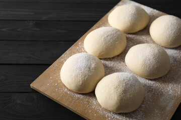 Wall Mural - Raw dough balls on black wooden table