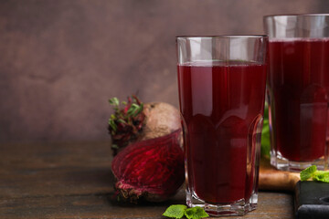 Sticker - Fresh beet juice in glasses and ripe vegetables on wooden table, closeup. Space for text