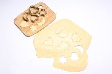 Wall Mural - Raw dough, wooden board and cookie cutters isolated on white, above view