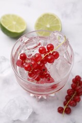 Sticker - Refreshing water with red currants in glass on white marble table, closeup