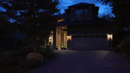 Wall Mural - Establishing shot of two story stucco luxury house with garage door, big tree and nice landscape at night in Vancouver, Canada, North America. Night time on June 2024. ProRes 422 HQ.