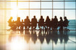 © Kitta - Dynamic Business Meeting: Professionals Engaged in Collaborative Discussions Against a Radiant Sunset Backdrop
