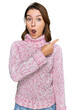 © Krakenimages.com - Young caucasian girl wearing wool winter sweater surprised pointing with finger to the side, open mouth amazed expression.