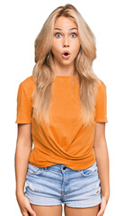 Poster - Young blonde girl wearing casual clothes scared and amazed with open mouth for surprise, disbelief face