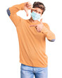 © Krakenimages.com - Young handsome man wearing medical mask smiling making frame with hands and fingers with happy face. creativity and photography concept.