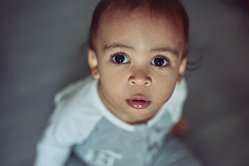 Cute, growth and portrait of boy baby in home for playing, learning or cognitive motor skills for development. Sweet, adorable and high angle of infant in nursery room for early childhood in house.