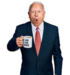 Poster - Senior business man with grey hair drinking from i am the boss coffee cup scared and amazed with open mouth for surprise, disbelief face