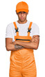 © Krakenimages.com - Young handsome african american man wearing handyman uniform skeptic and nervous, disapproving expression on face with crossed arms. negative person.