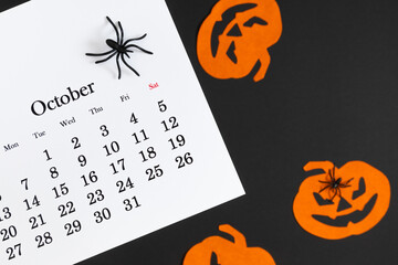 Wall Mural - Calendar 31st of October date. Halloween background, planning party. Flat lay. Top view photo of calendar, Halloween decorations pumpkins, spiders on black and orange background.