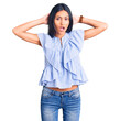 © Krakenimages.com - Young beautiful latin girl wearing casual clothes crazy and scared with hands on head, afraid and surprised of shock with open mouth
