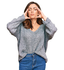 Canvas Print - Young brunette woman wearing casual winter sweater suffering from headache desperate and stressed because pain and migraine. hands on head.