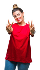 Wall Mural - Young beautiful woman over isolated background smiling looking to the camera showing fingers doing victory sign. Number two.