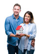 © Krakenimages.com - Young couple in love holding house over isolated background with a happy face standing and smiling with a confident smile showing teeth