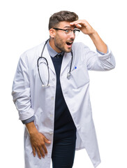 Wall Mural - Young handsome doctor man over isolated background very happy and smiling looking far away with hand over head. Searching concept.