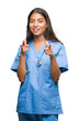 © Krakenimages.com - Young arab doctor surgeon woman over isolated background pointing fingers to camera with happy and funny face. Good energy and vibes.